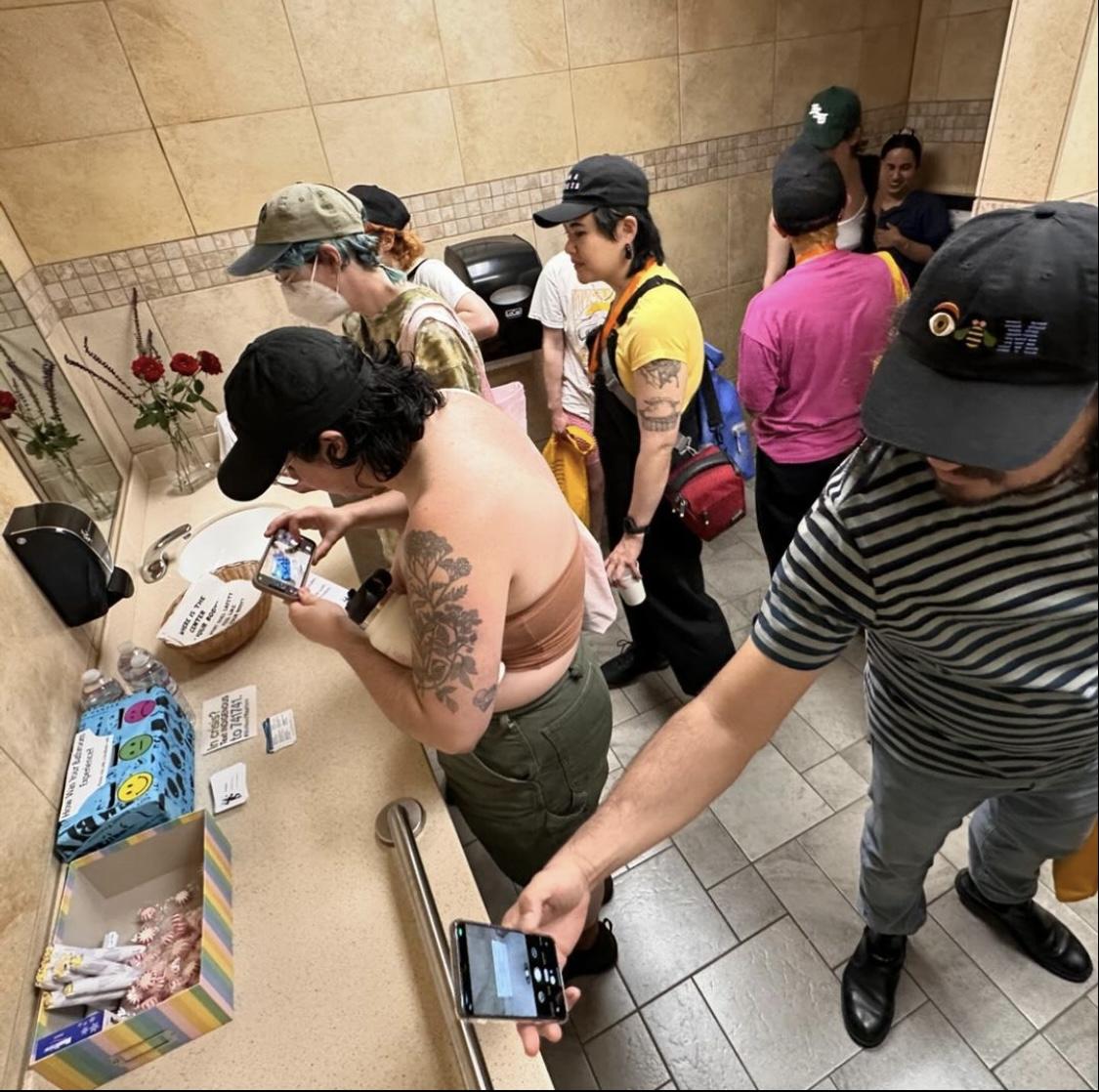 group of people in the bathroom taking items with them