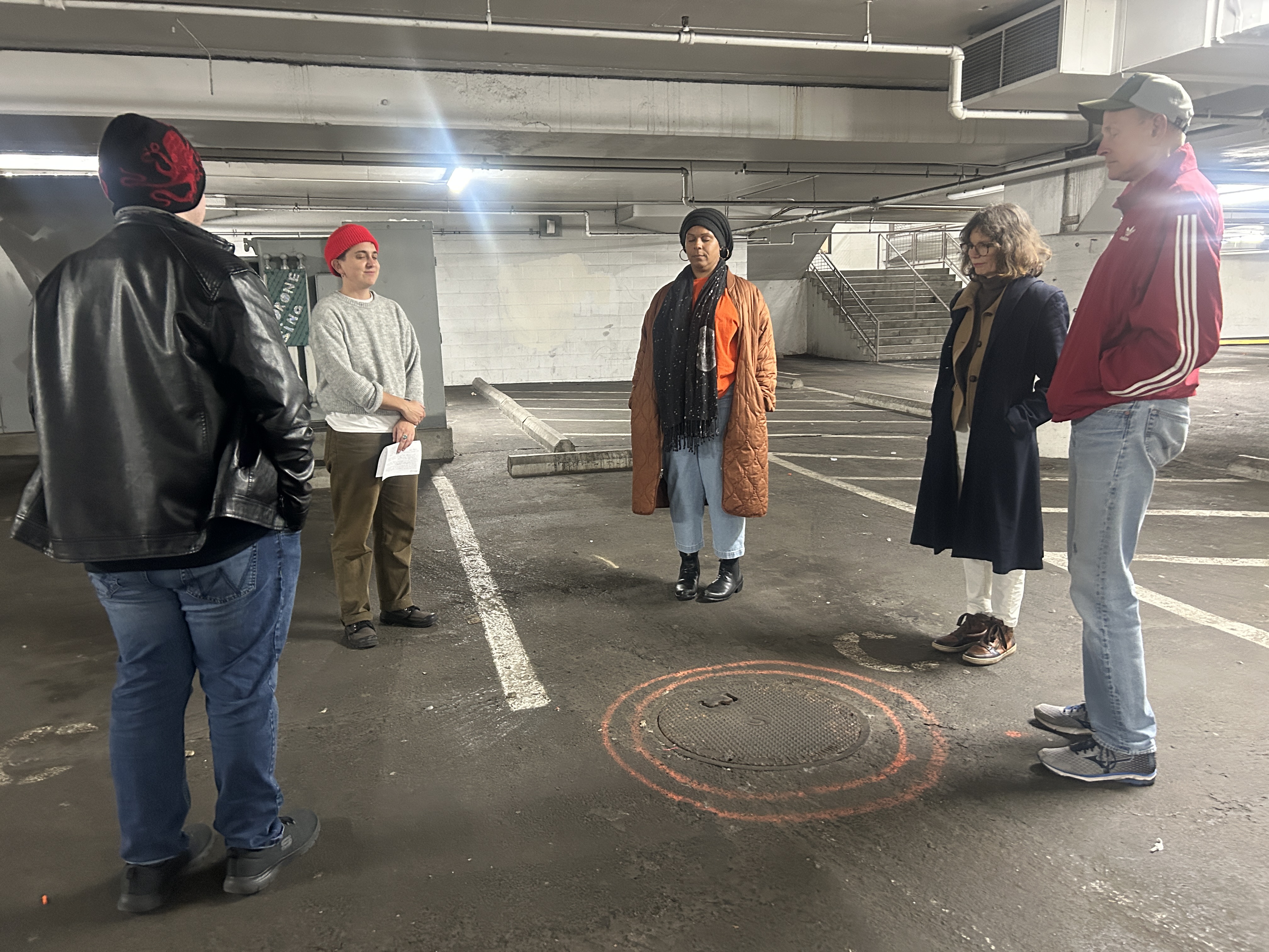 a group of people in a circle in a mall parking garage basement