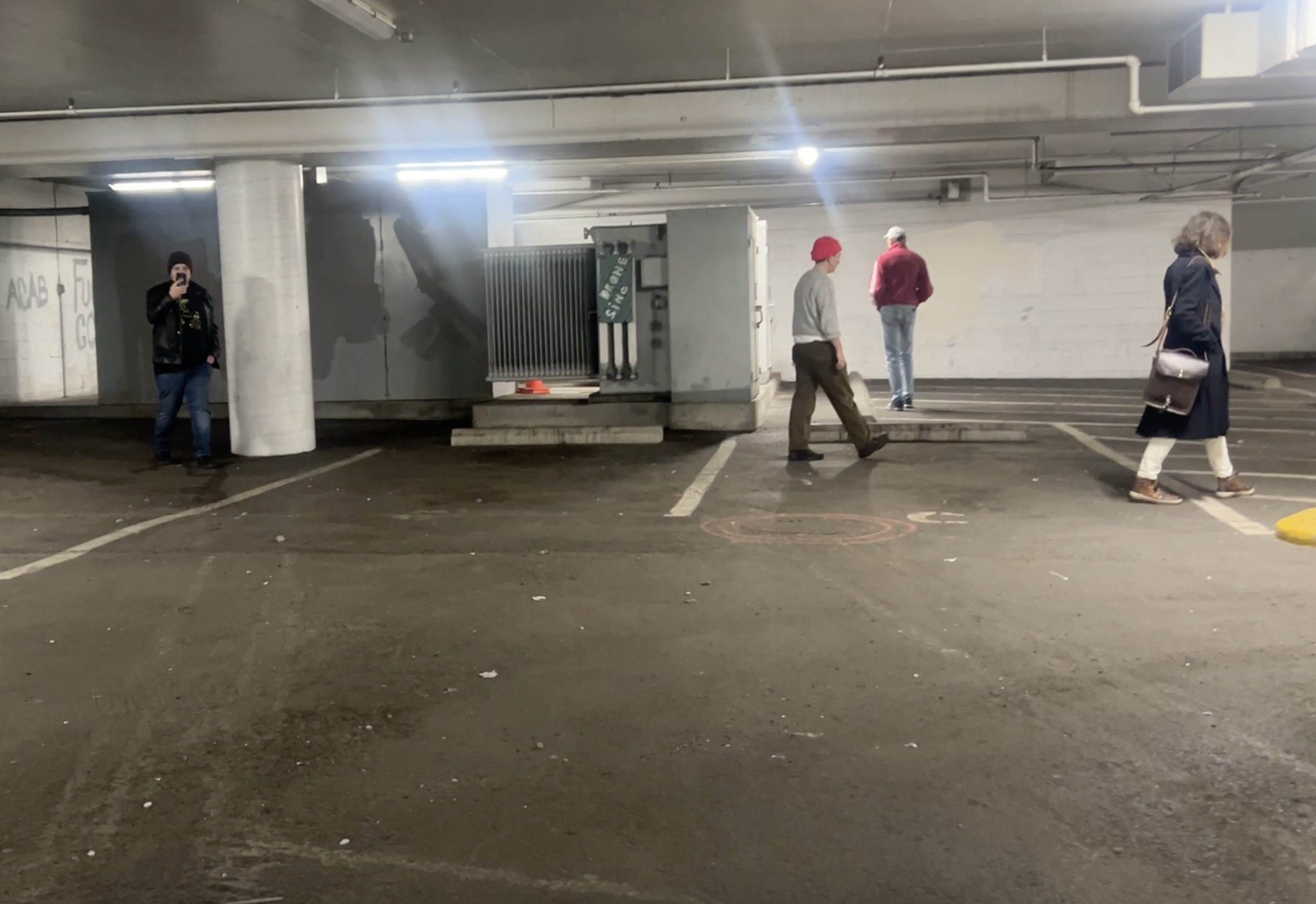 four people walking around a basement machine